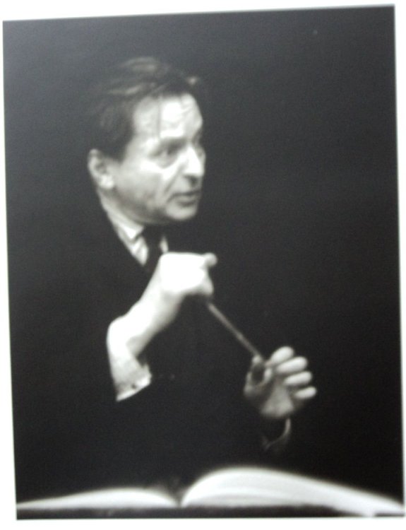 A HANDSOME BLACK & WHITE PORTRAIT OF THE GREAT ROMANIAN COMPOSER & CONDUCTOR GEORGE ENESCU, BATON IN HAND, INTENSELY LOOKING UP FROM A SCORE.