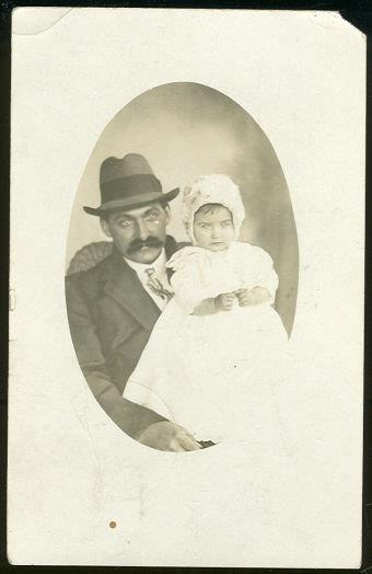REAL PHOTO POSTCARD OF JAMES HOLDING THE BABY